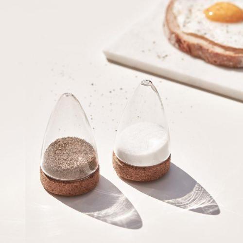 Puik design salt and pepper shakers partially filled on a sunlit table